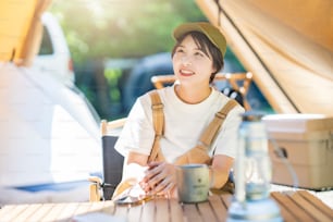 Jeune femme se relaxant dans un camping par beau temps
