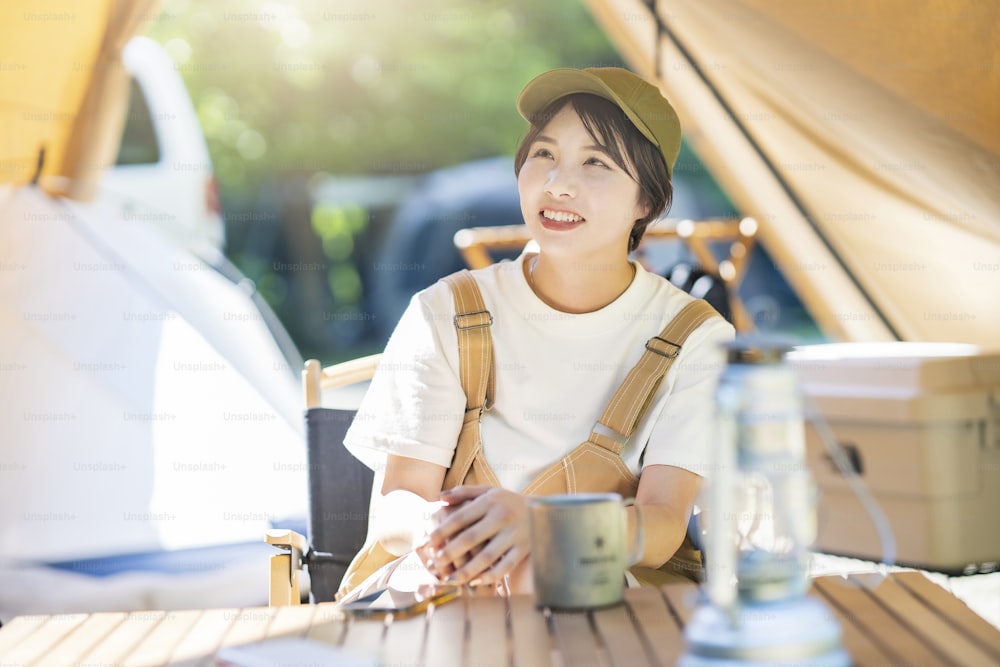 Young woman relaxing at a campsite on fine day