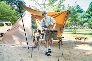 Young woman relaxing at a campsite on fine day