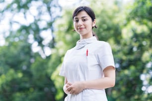 Outdoor portrait of young woman posing in white coat on fine day
