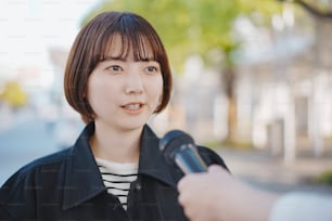 Giovane donna asiatica intervistata per strada della città