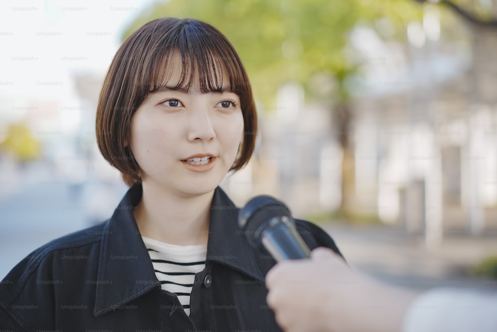 Joven asiática entrevistada en la calle de la ciudad