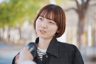 Giovane donna asiatica intervistata per strada della città