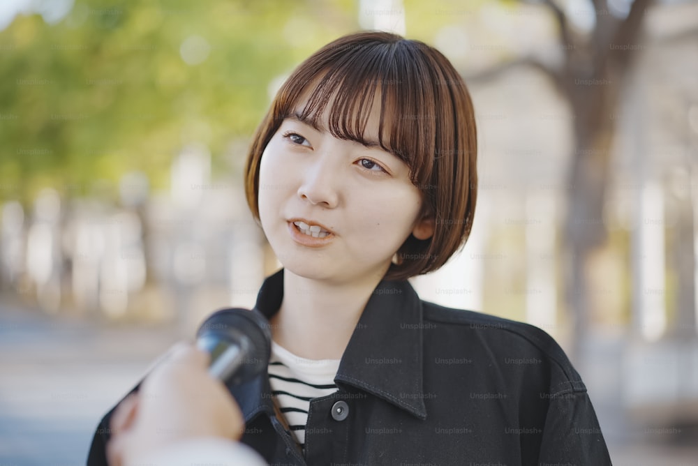 도시의 거리에서 인터뷰한 아시아의 젊은 여성
