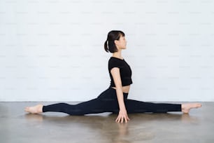 Una mujer haciendo yoga (pose del rey mono)
