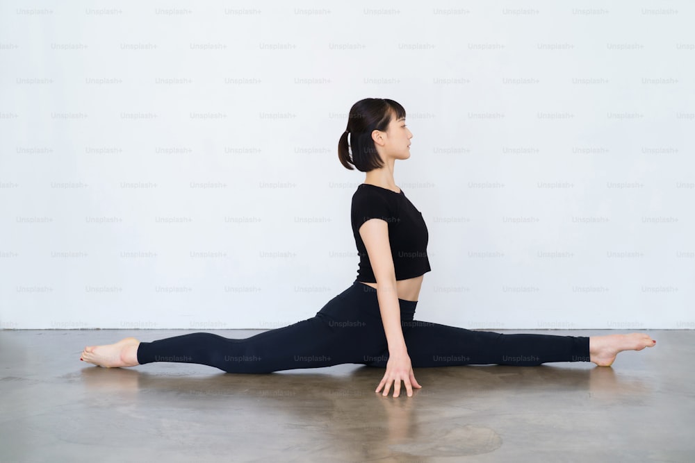 Eine Frau, die Yoga macht (Affenkönig-Pose)