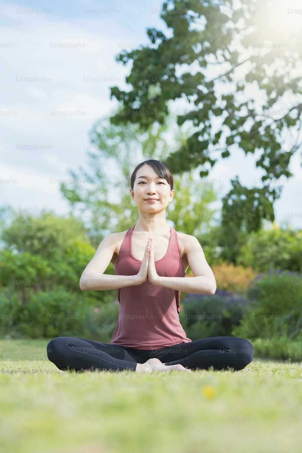 Mujer joven haciendo yoga en un parque verde en un buen día