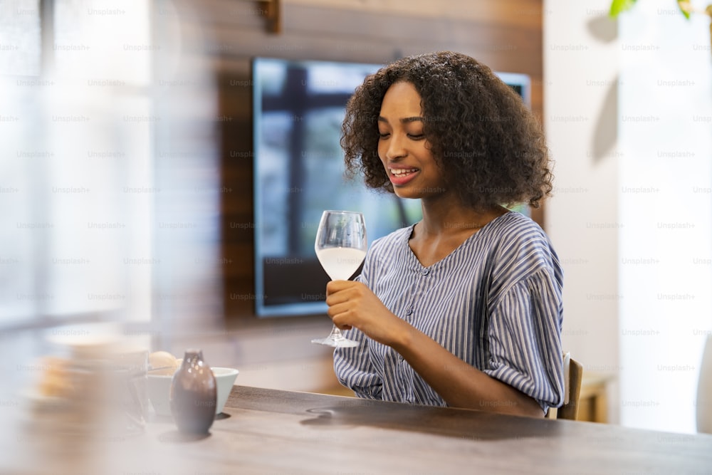 Junge Frau plaudert mit einem Weinglas in der Hand