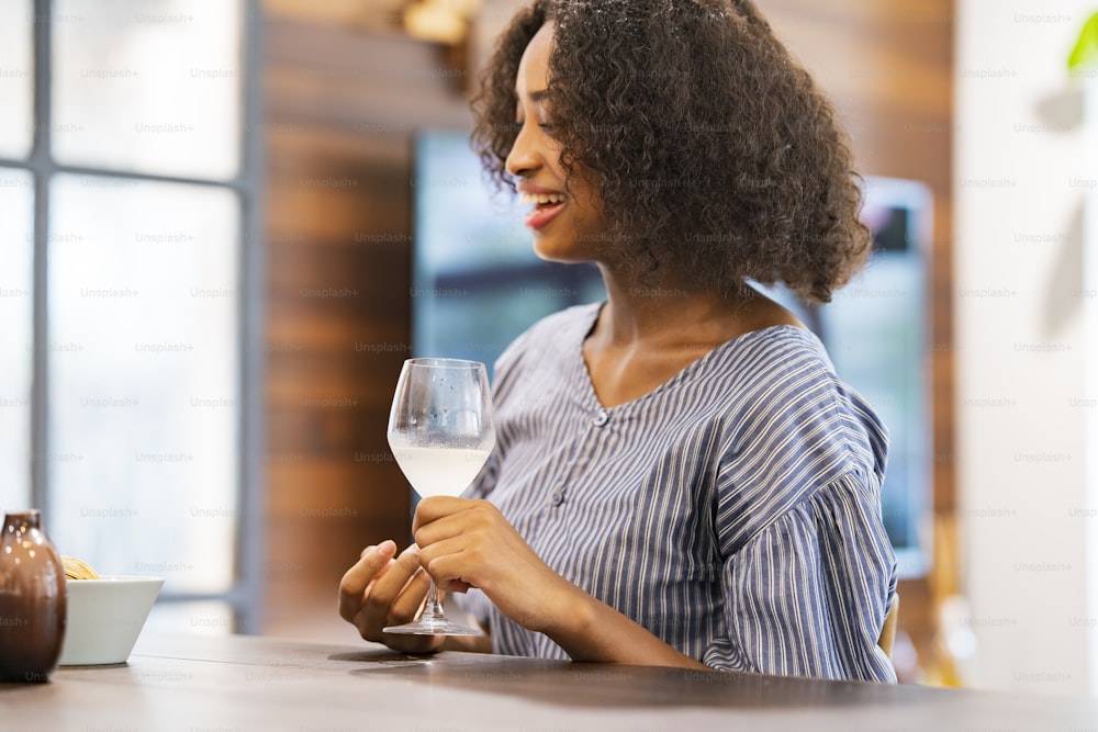 Jeune femme bavardant avec un verre de vin à la main