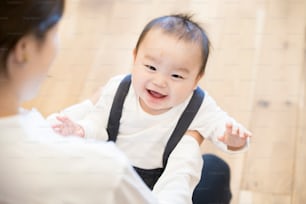Asian young mom holding a baby with smile