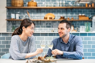 Image photograph of man and woman toasting at dining kitchen