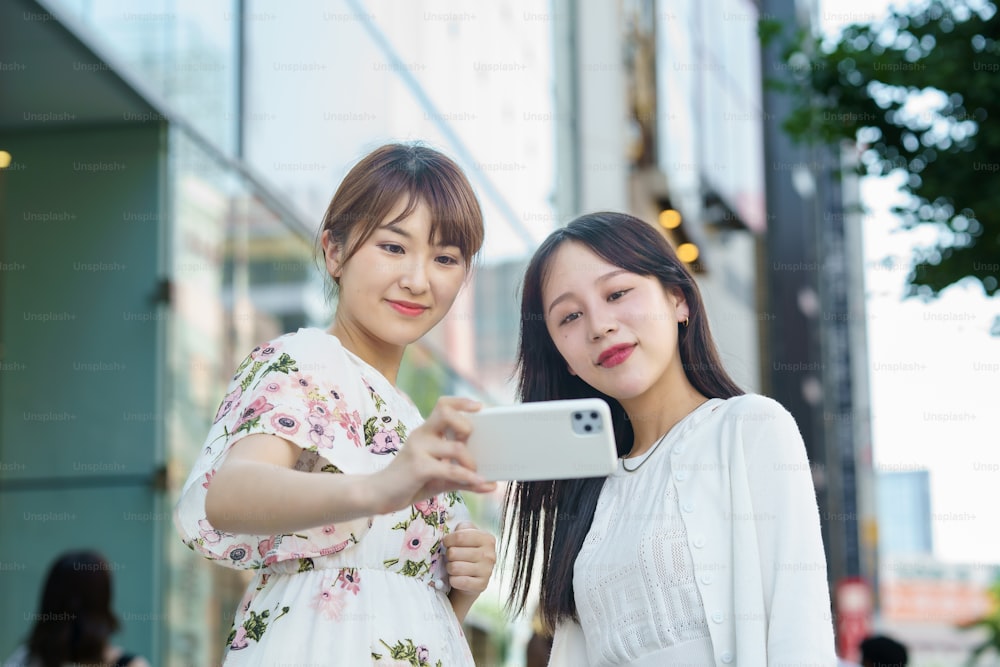 Mujeres jóvenes tomándose selfies en la ciudad