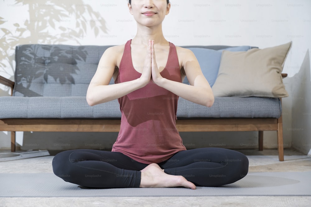 Young woman with yoga wear doing yoga in the room