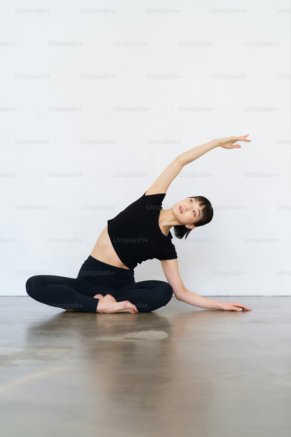 Junge Frau, die Yoga und flexible Übungen in Innenräumen macht