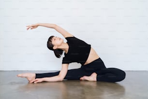 Giovane donna che fa yoga ed esercizio flessibile all'interno