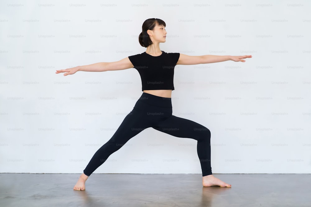 Jeune femme faisant du yoga (pose guerrière)