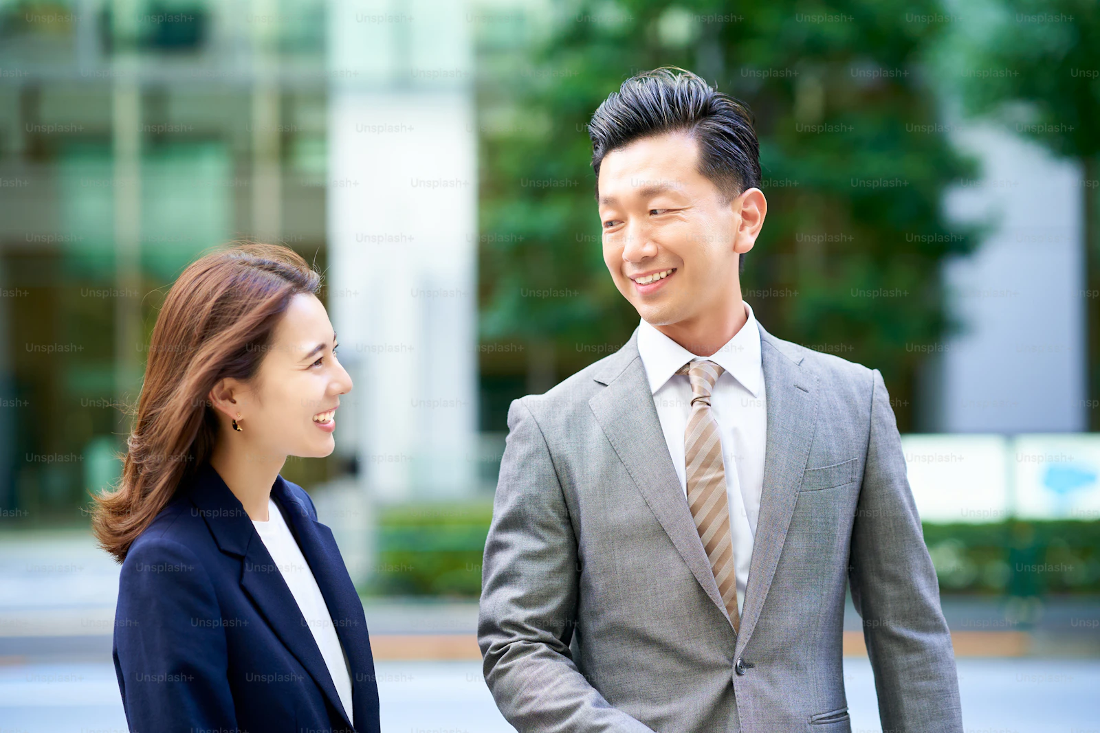 Business man and woman in suits standing outdoors