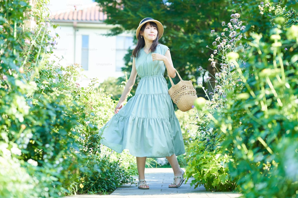 좋은 날에 녹색으로 걷는 젊은 여자