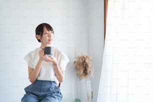 A woman with mug relaxing in a simple space