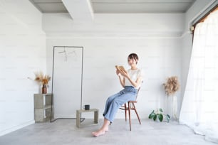 A woman reading a book in a simple bright room