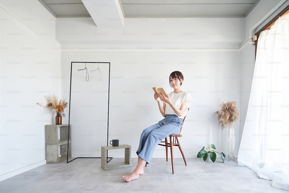 Eine Frau, die ein Buch in einem einfachen, hellen Raum liest