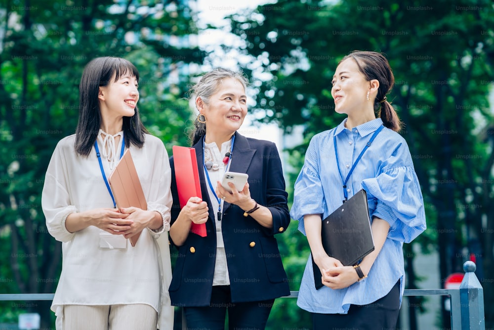 A business team centered on gray-haired woman outdoors