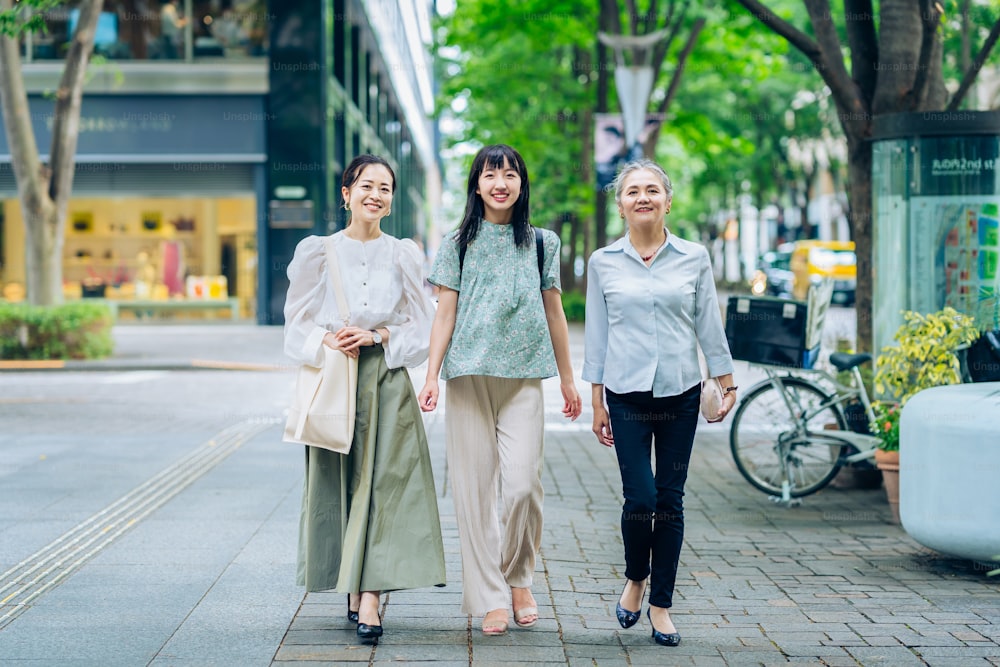 Tres mujeres de varias generaciones caminando por la ciudad en un buen día