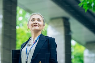 Asian gray-haired business woman standing outdoors