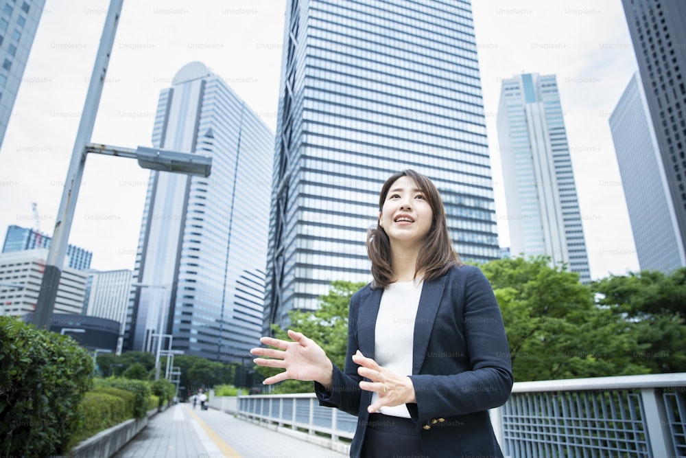 Mujer de negocios asiática que viaja al distrito de negocios con ropa casual de negocios