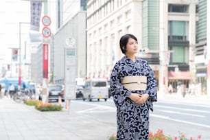 Mulher asiática (japonesa) que vai para a cidade vestindo um yukata (traje tradicional japonês)