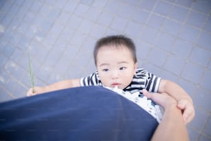 Two year old boy and his mother playing in the park on a sunny day