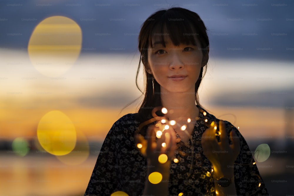 Asian young woman staring at the illumination lights in evening time