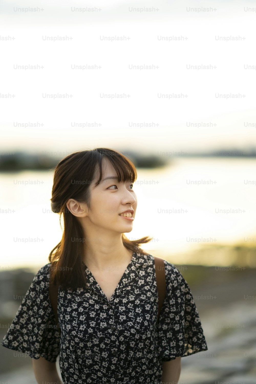 portrait of asian young woman standing by the sea in evening
