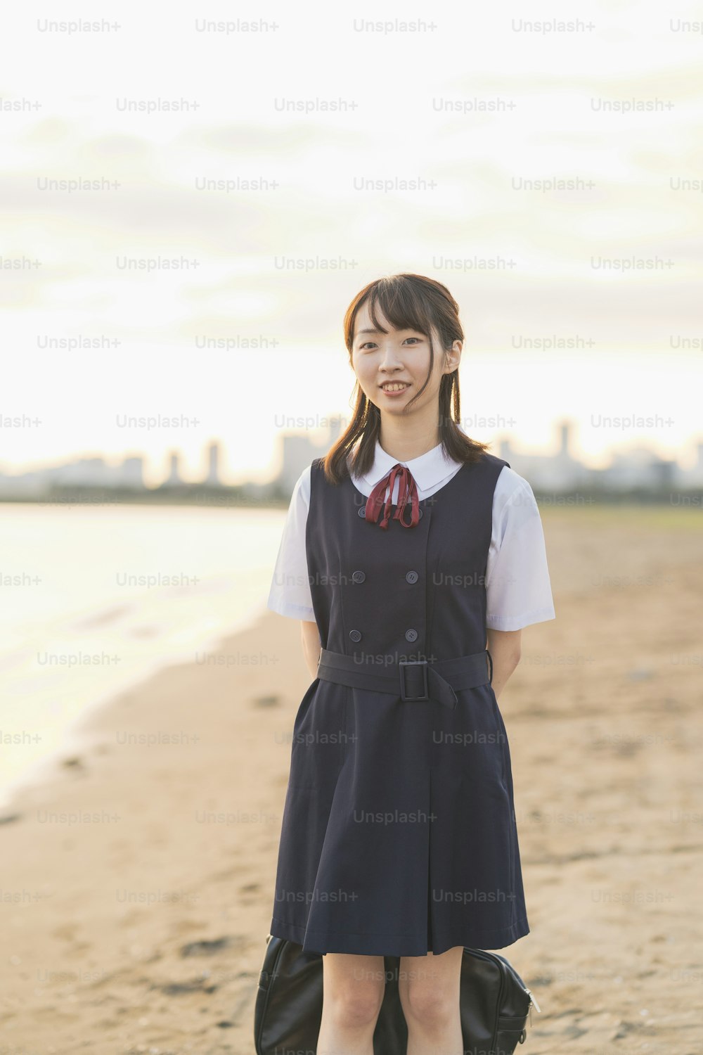 浜辺を歩くアジア女子高校生