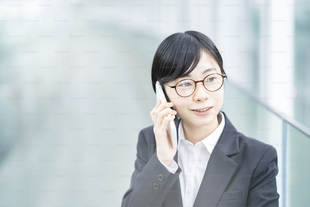 A young woman in a suit talking on a smartphone