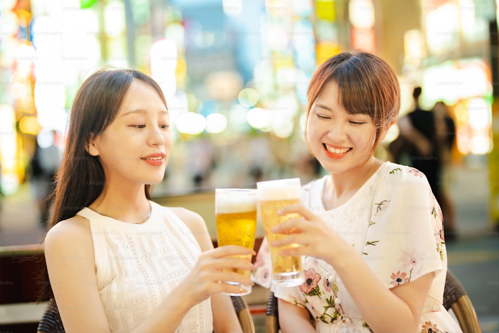 Two women with a glass of beer at night