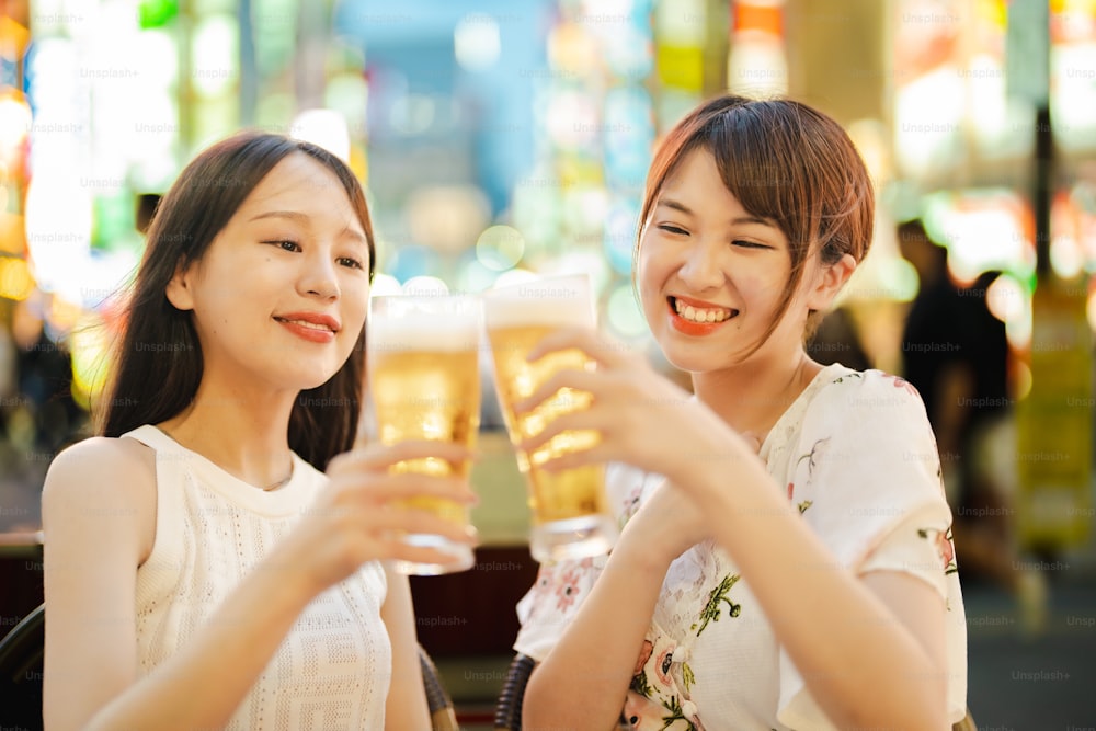 Two women with a glass of beer at night
