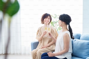 Two women chatting with champagne glasses in their hands with a smile