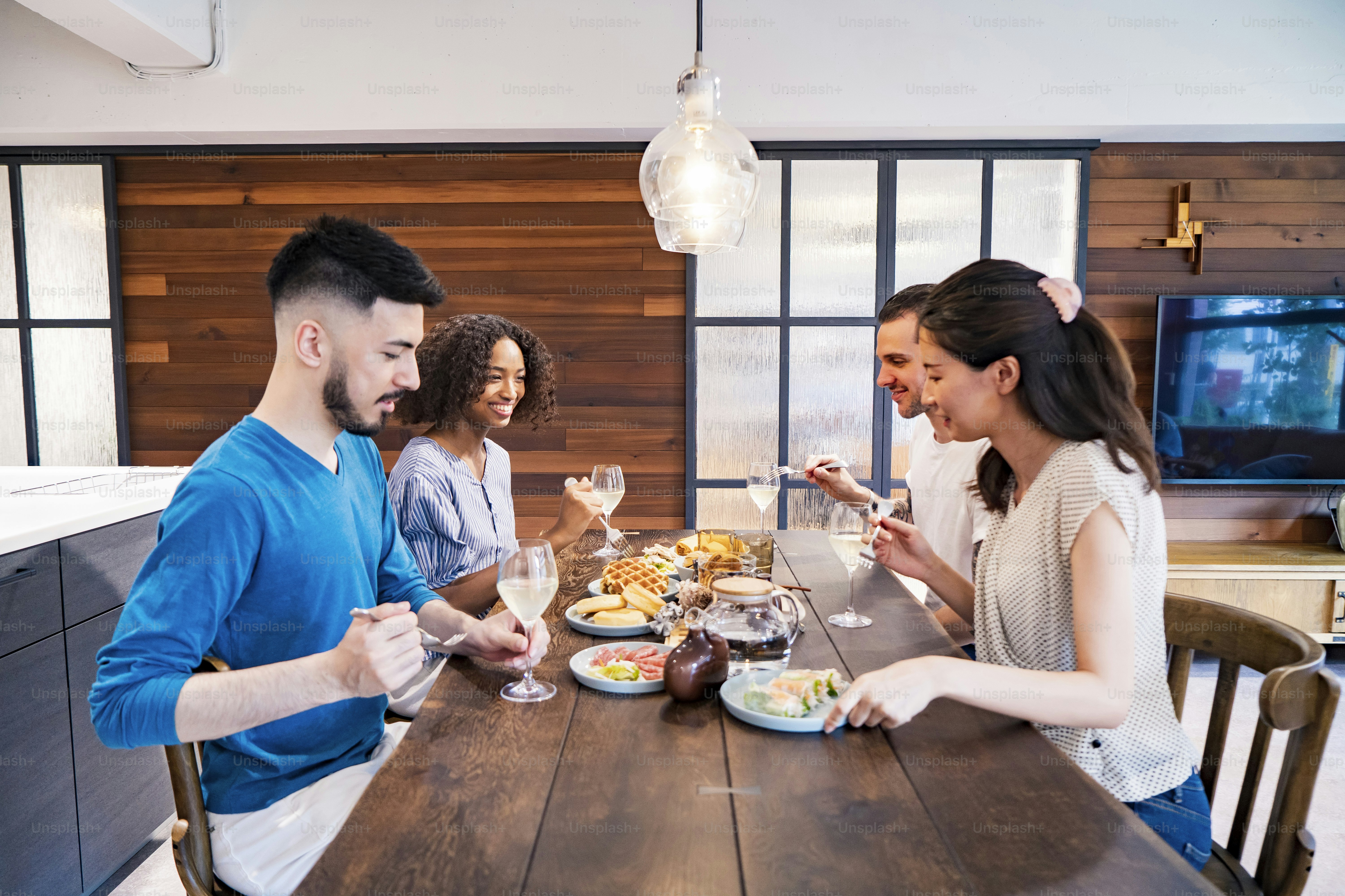 Scene of a home party where men and women surround the dining table