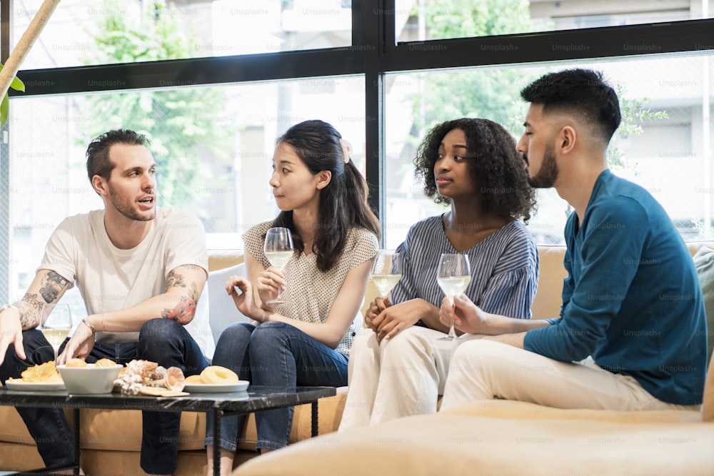 Men and women having a house party and having fun chatting