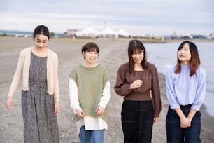 Vier asiatische junge Frauen unterhalten sich glücklich in der Dämmerung