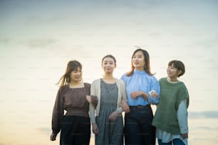 Four asian young women talking happily in the dusk