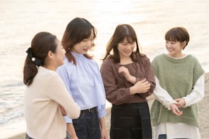 황혼에 행복하게 이야기하는 네 명의 아시아 젊은 여성