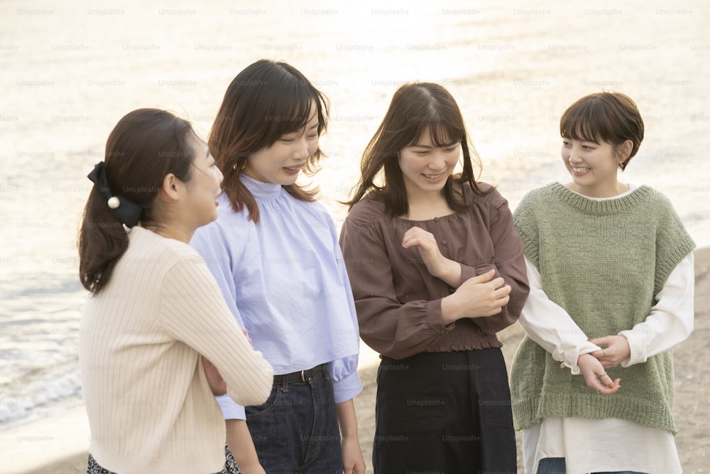 Quatre jeunes femmes asiatiques parlant joyeusement au crépuscule
