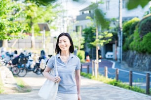 Middle-aged woman taking a walk with a relaxed look on fine day