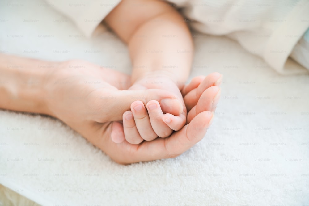 La mano de la madre sosteniendo la mano de su bebé