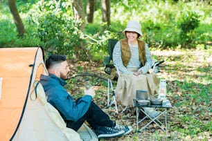 Homme et femme profitant du camping dans la forêt