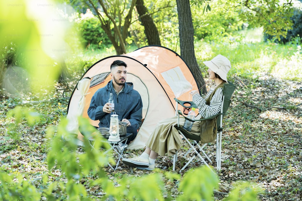 森でキャンプを楽しむ男女