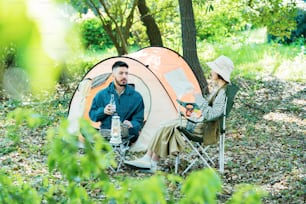 Homme et femme profitant du camping dans la forêt