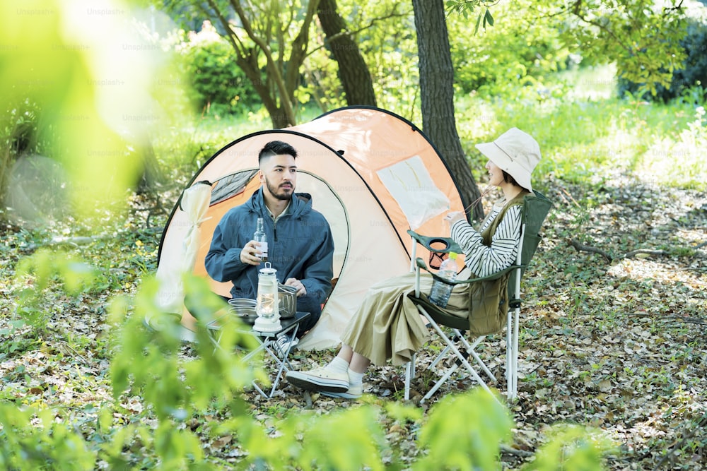 Man and woman enjoying camping in the forest